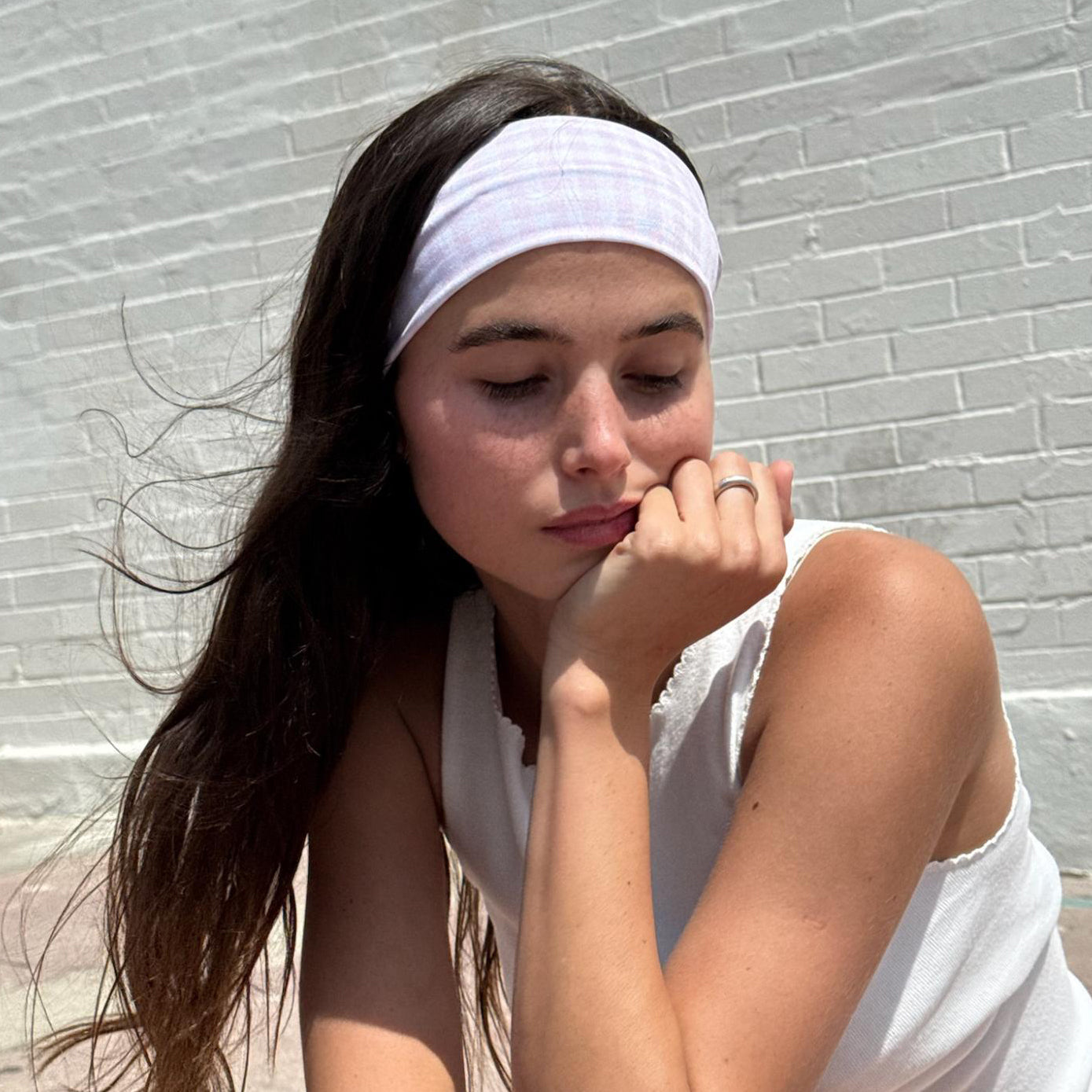 model with chin on hand wearing Infinity Headband in Baby Pink Gingham in hair
