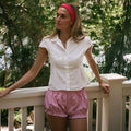 model leaning against railing while wearing Ruffle Headband in Cherry Kiss